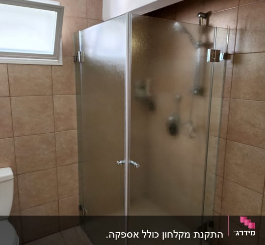 מקלחון זכוכית עם דלתות מתכת בחדר אמבטיה